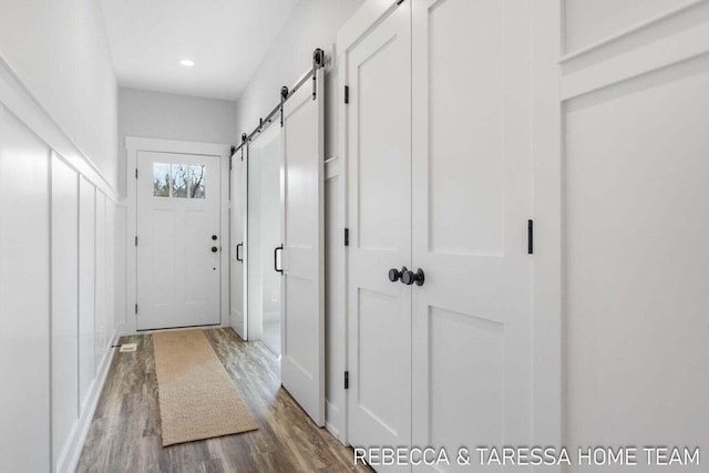 interior space with a barn door and hardwood / wood-style floors