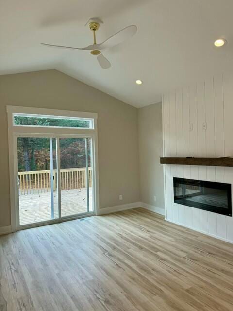 unfurnished living room featuring lofted ceiling, a fireplace, light hardwood / wood-style floors, and ceiling fan