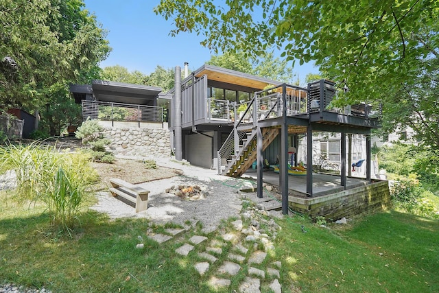 rear view of house with stairs, a yard, and a wooden deck