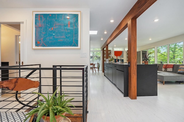 hall featuring recessed lighting, a sink, and an upstairs landing