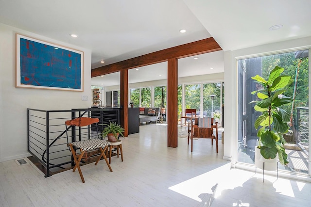 interior space featuring light wood-style floors, recessed lighting, beam ceiling, and visible vents