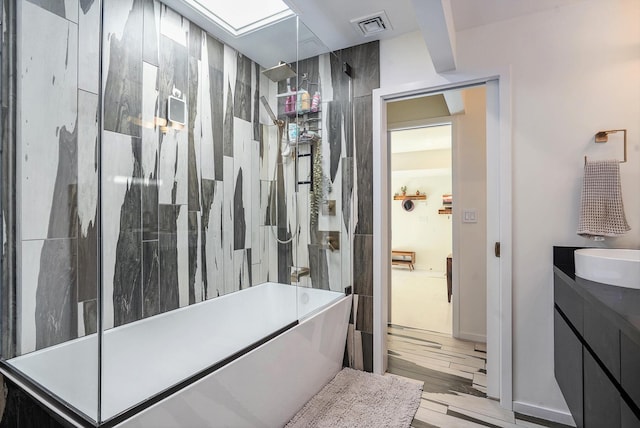 full bathroom with visible vents, shower / bathing tub combination, vanity, and wood finished floors