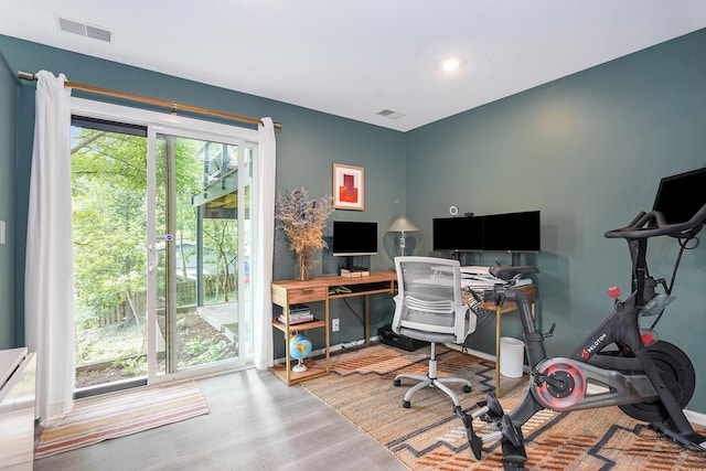 home office with baseboards, visible vents, and wood finished floors