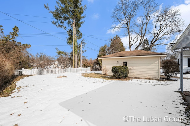 snowy yard featuring an outbuilding