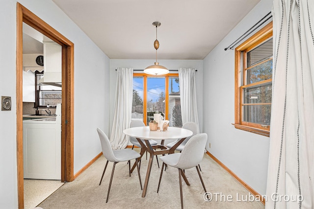 carpeted dining room with washer / dryer