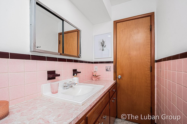 bathroom with vanity and tile walls