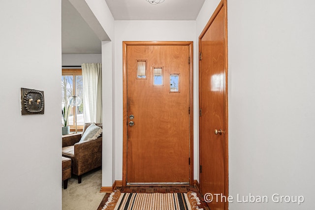 foyer entrance featuring light carpet