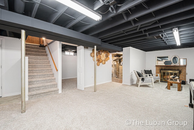 basement featuring carpet floors and a brick fireplace