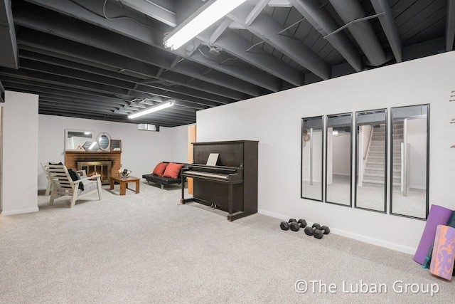 basement with light colored carpet and a fireplace