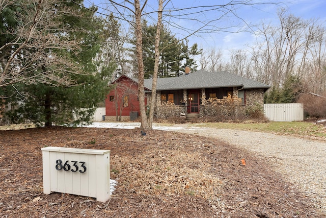 view of front of house featuring roof with shingles, fence, and a chimney