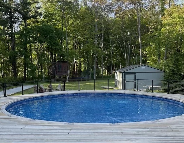 view of swimming pool featuring an outbuilding, a lawn, fence, and a fenced in pool