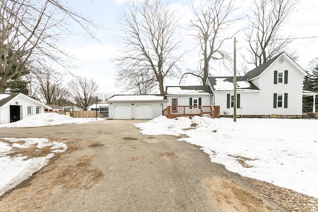 view of front facade featuring an attached garage, driveway, and a wooden deck