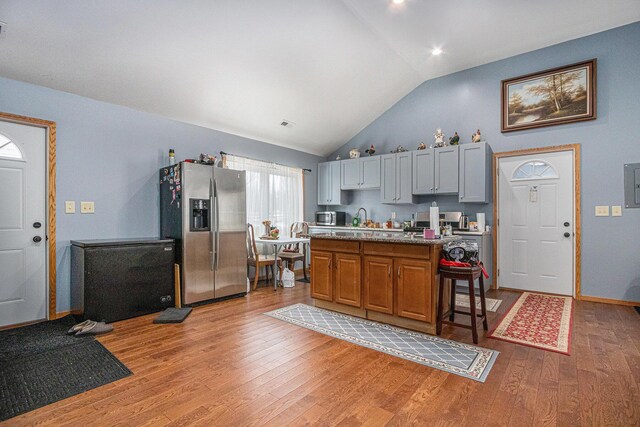 37076 76th St, Covert, MI 49043 - kitchen with a sink, stainless steel fridge with ice dispenser, light wood-type flooring, a kitchen bar, and a kitchen island