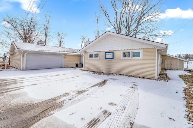 view of front of home featuring a garage and a storage unit