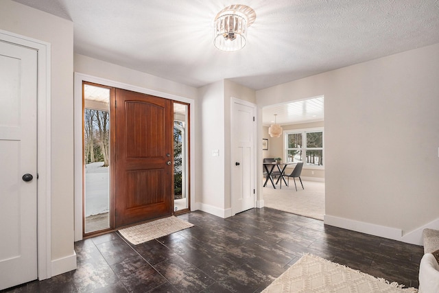 entryway featuring a notable chandelier and a textured ceiling