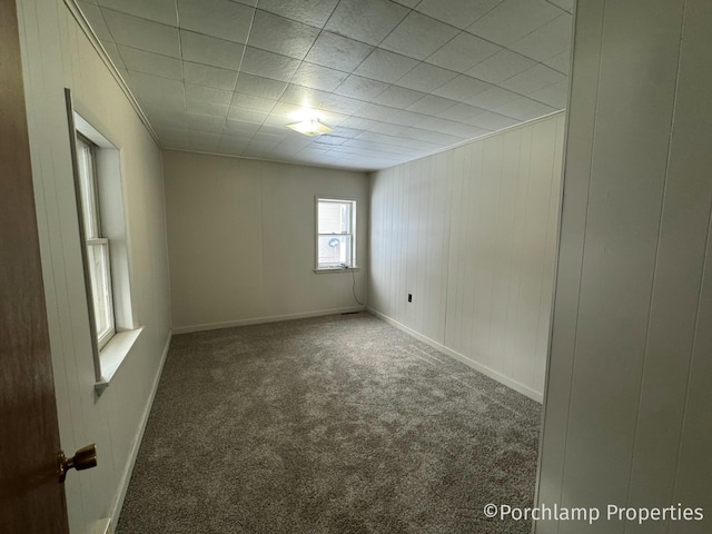 carpeted spare room featuring baseboards