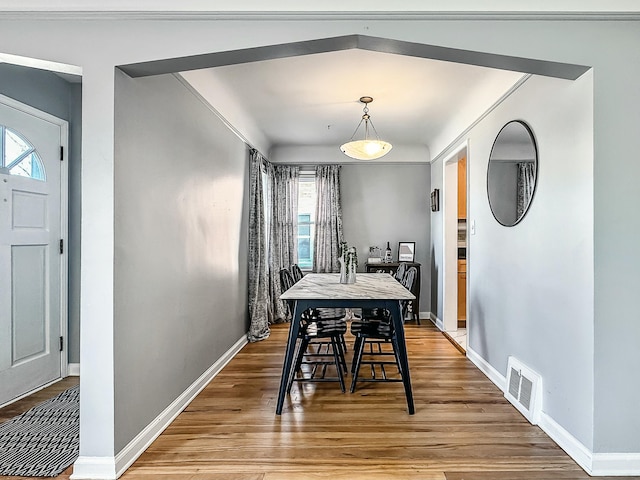 dining room with visible vents, baseboards, and wood finished floors