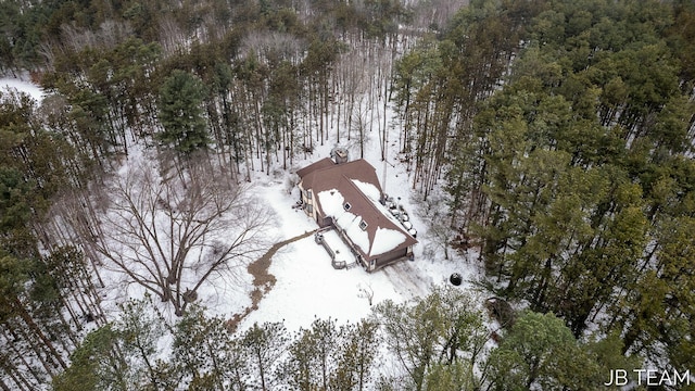 snowy aerial view with a wooded view