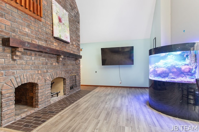 living area featuring a fireplace, baseboards, and wood finished floors