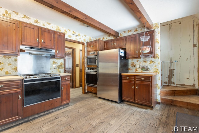 kitchen featuring stainless steel appliances, light countertops, light wood-style floors, beamed ceiling, and under cabinet range hood