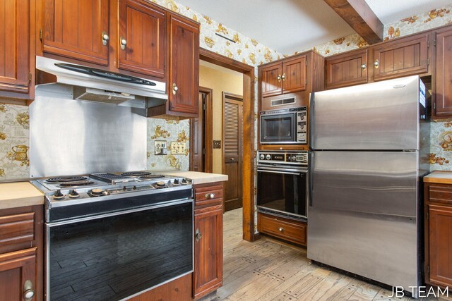 kitchen with stainless steel appliances, light countertops, and under cabinet range hood