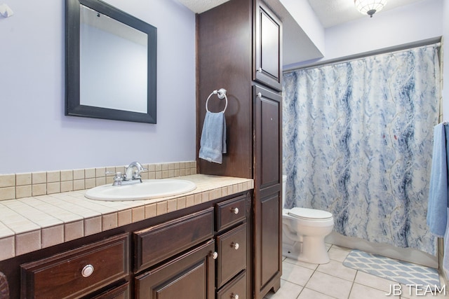 full bathroom with tile patterned flooring, curtained shower, vanity, and toilet