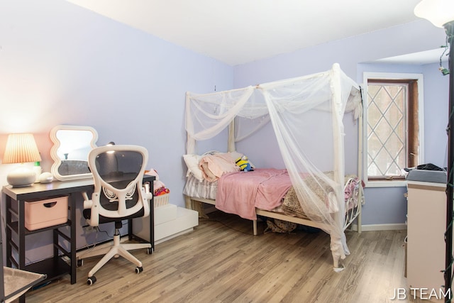 bedroom featuring wood finished floors and baseboards