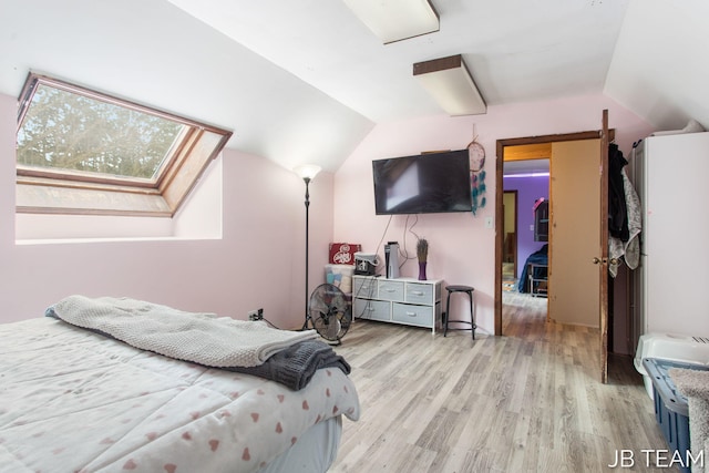 bedroom with light wood-type flooring and vaulted ceiling with skylight