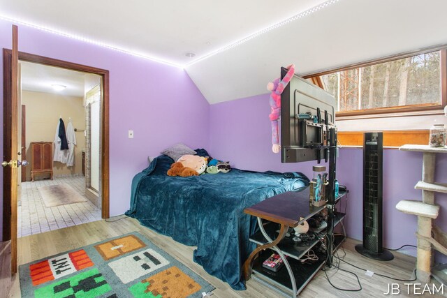 bedroom featuring lofted ceiling and light wood-style floors