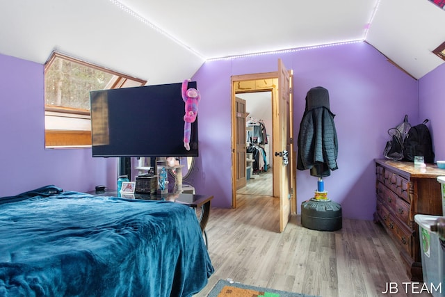 bedroom featuring lofted ceiling and light wood-style flooring