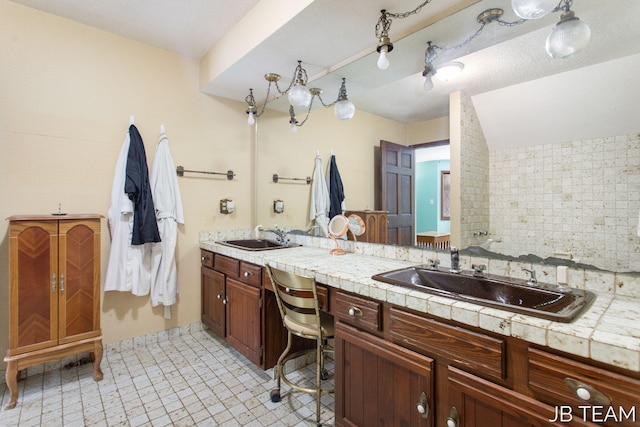 full bathroom with a sink, backsplash, and double vanity