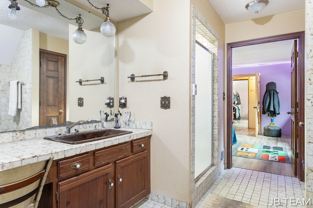 bathroom with tile patterned floors, a shower stall, and vanity