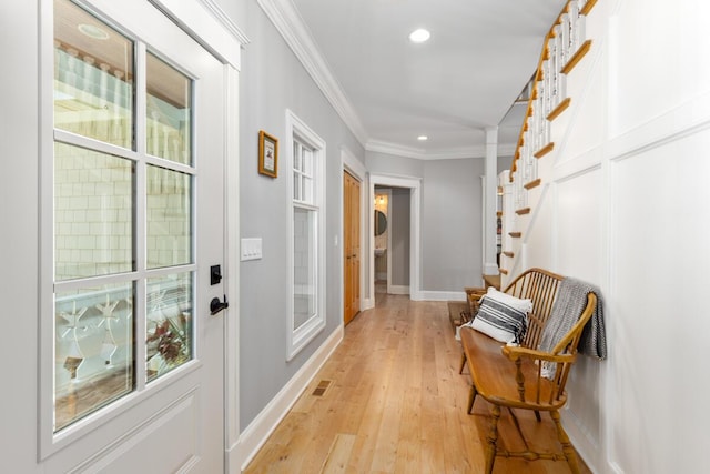 doorway to outside with crown molding and light wood-type flooring