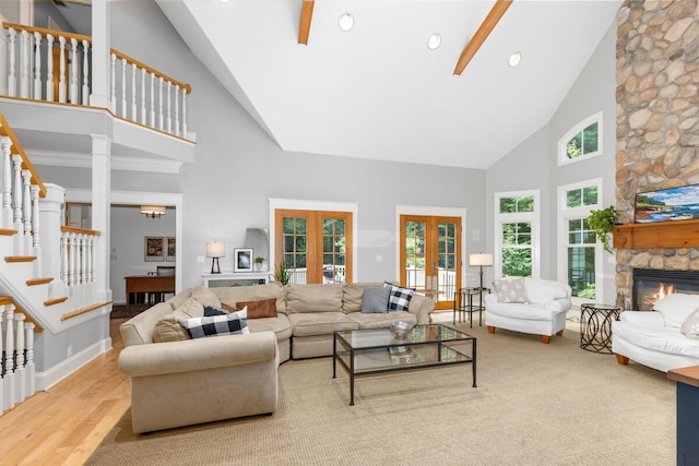 living room featuring ceiling fan, high vaulted ceiling, a fireplace, french doors, and light wood-type flooring