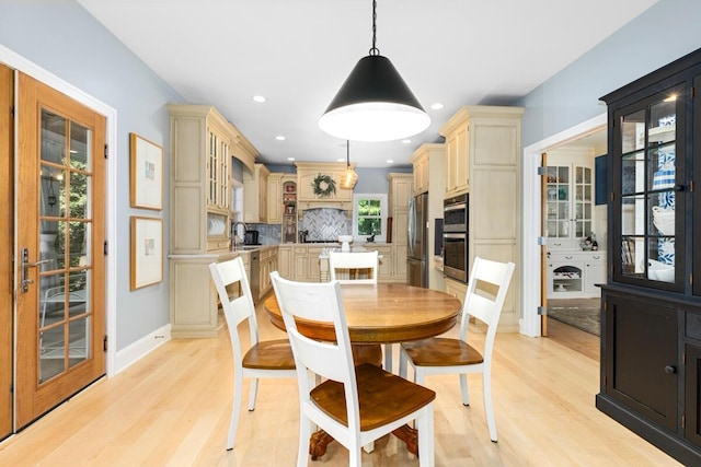 dining area with sink and light wood-type flooring