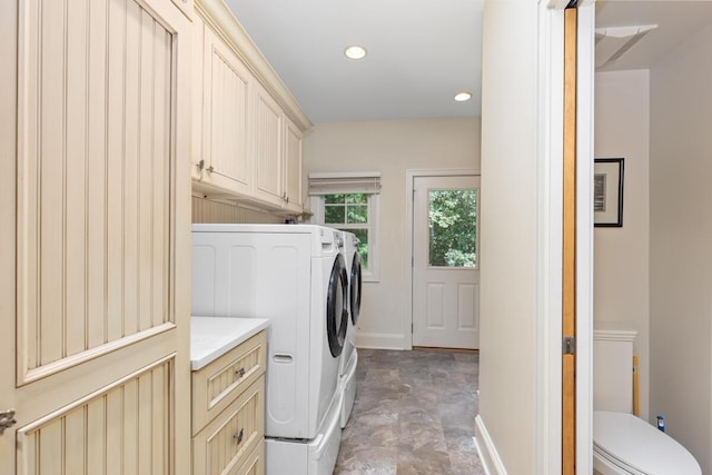 clothes washing area featuring cabinets and washer and dryer