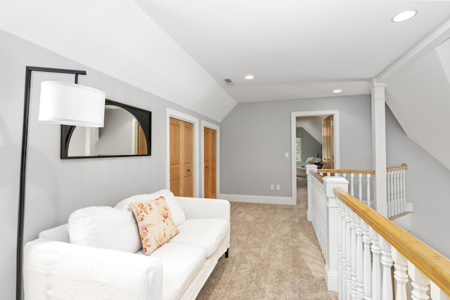 sitting room with vaulted ceiling and light colored carpet