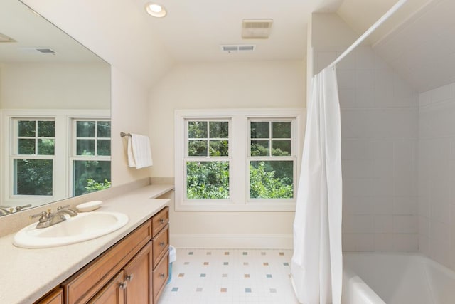 bathroom with vanity, lofted ceiling, and shower / bathtub combination with curtain