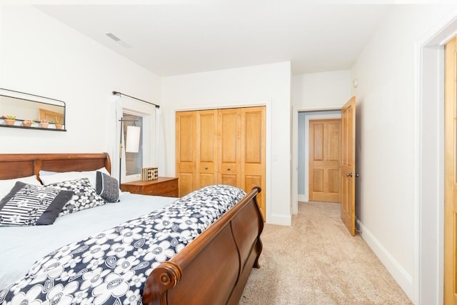 bedroom featuring light colored carpet and a closet