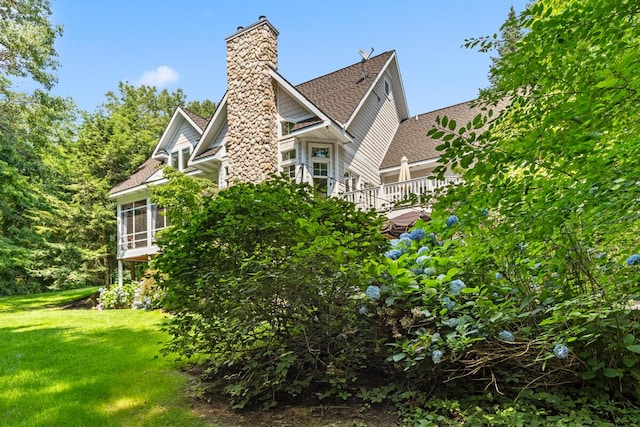 view of side of property with a yard and a sunroom