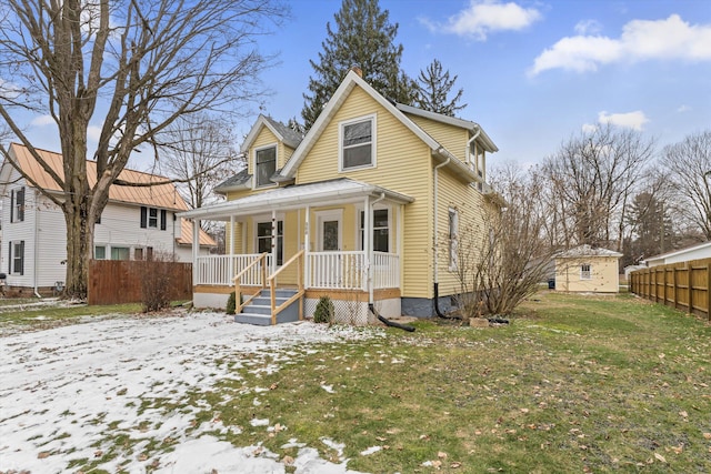 view of front of property featuring a lawn, a storage unit, and a porch