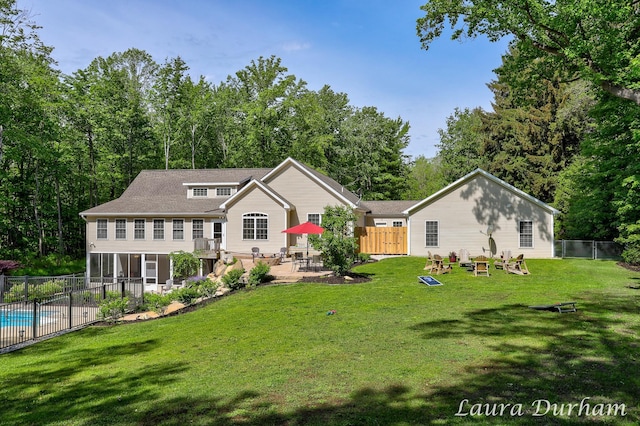 view of front facade with a fenced in pool, a sunroom, fence, a patio area, and a front yard