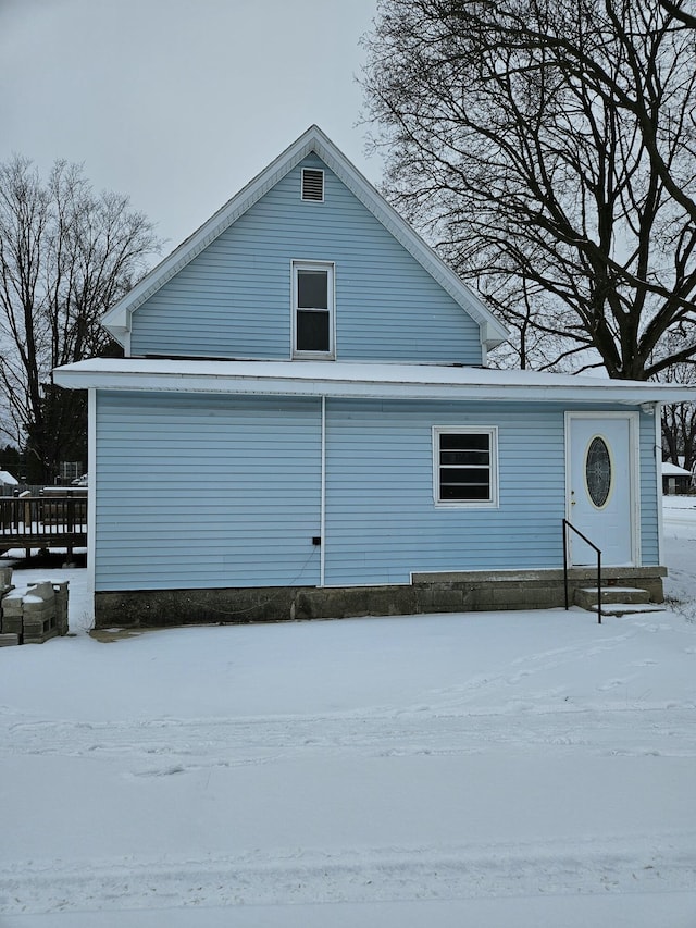 view of snow covered rear of property