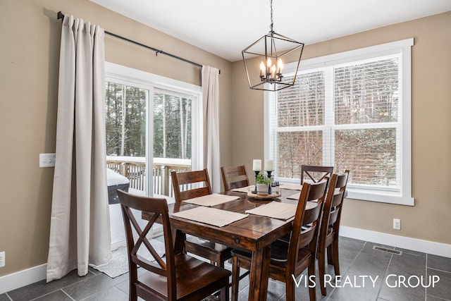 9340 Freedom Dr, West Olive, MI 49460 - dining space with a chandelier, visible vents, and baseboards
