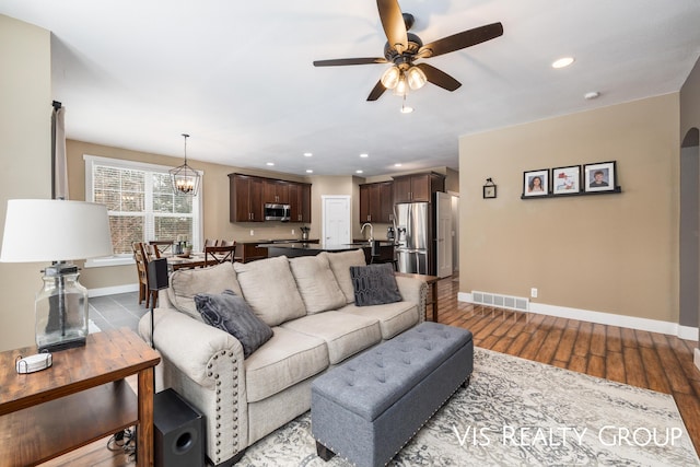 9340 Freedom Dr, West Olive, MI 49460 - living area featuring visible vents, ceiling fan with notable chandelier, baseboards, and wood finished floors