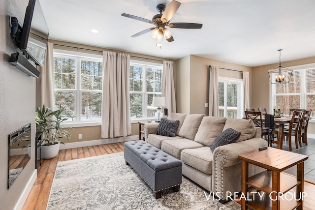 9340 Freedom Dr, West Olive, MI 49460 - living area with wood finished floors, ceiling fan with notable chandelier, baseboards, and a healthy amount of sunlight