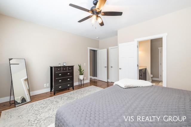 9340 Freedom Dr, West Olive, MI 49460 - bedroom featuring ensuite bathroom, baseboards, ceiling fan, and wood finished floors