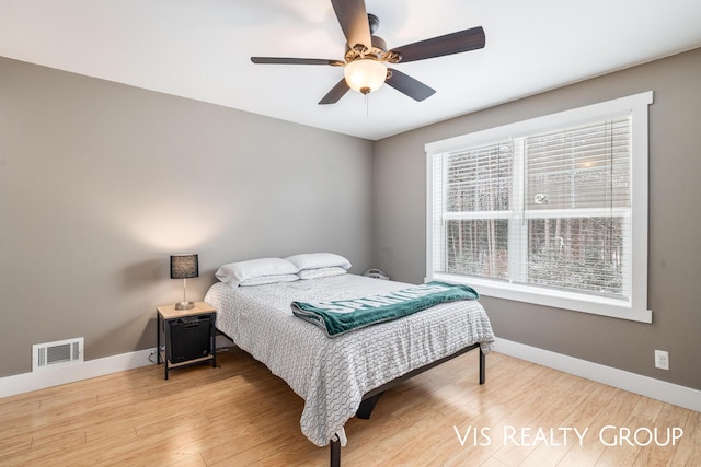 9340 Freedom Dr, West Olive, MI 49460 - bedroom with wood finished floors, ceiling fan, baseboards, and visible vents
