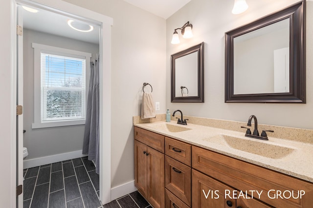 9340 Freedom Dr, West Olive, MI 49460 - bathroom with double vanity, a sink, and baseboards