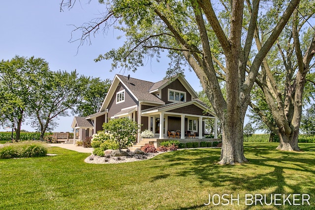 craftsman house featuring covered porch and a front yard